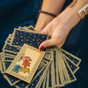 Close-up of a hand holding tarot cards, symbolizing spirituality and divination.