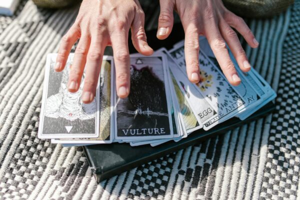 Close-up of hands on tarot cards, suggestive of divination or spiritual guidance.